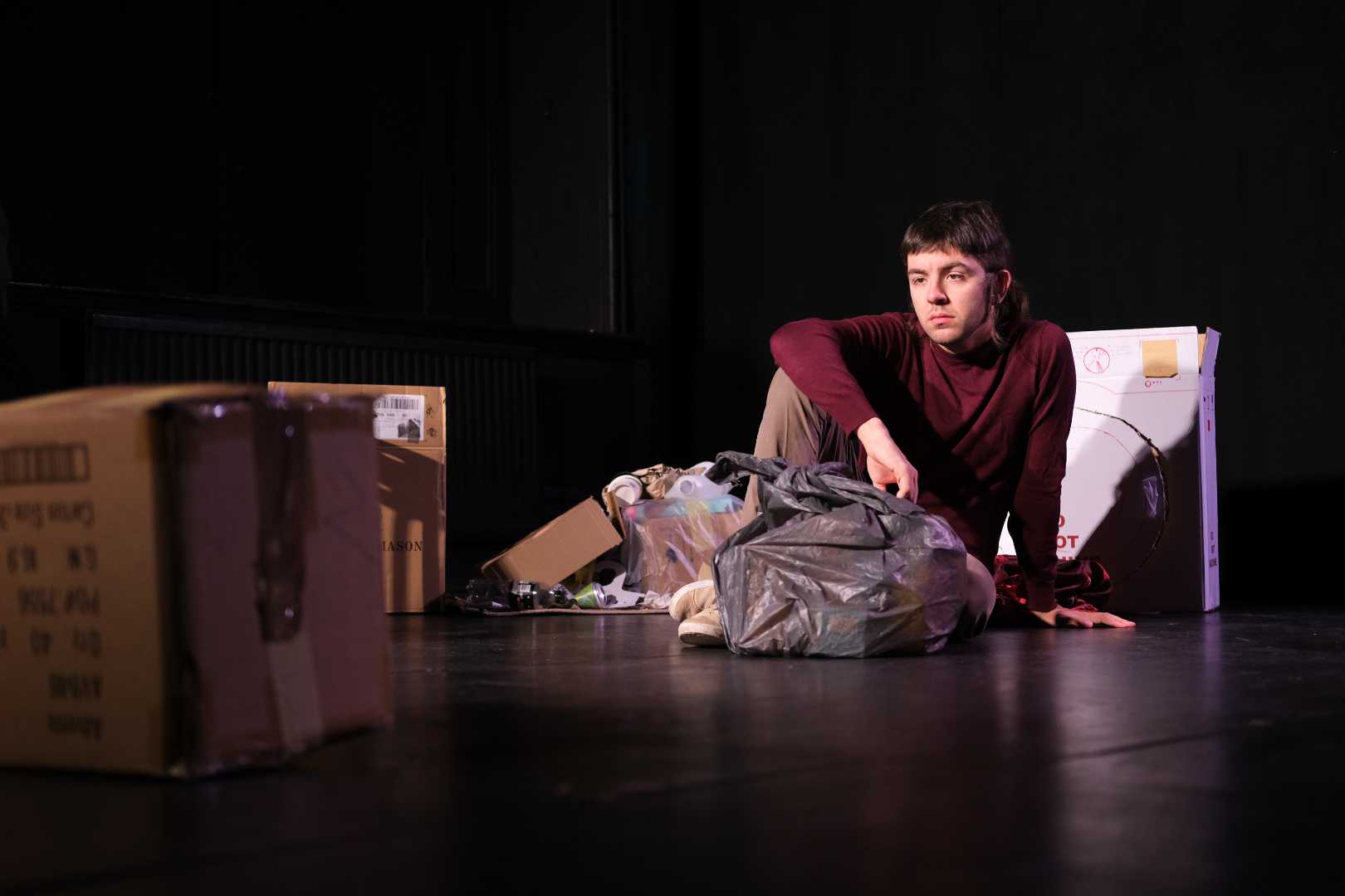 Orson Bourne as Man sitting among moving boxes and black bin bags in Have You Took The Bins Out? at Drayton Arms Theatre.
